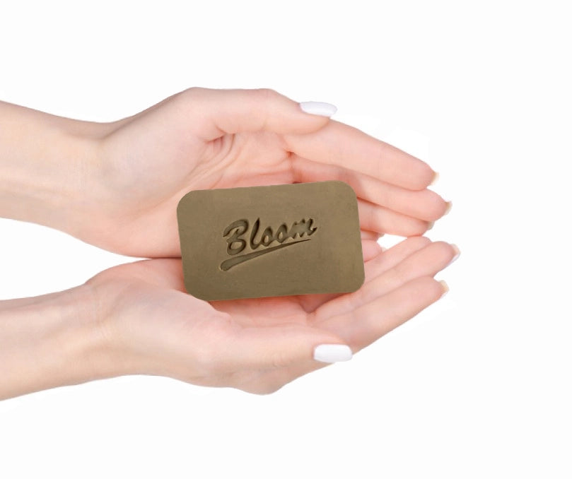 Bloom Dead Sea Organic Mud Soap bar, featuring a dark, textured surface, designed to cleanse and nourish the skin with natural minerals.